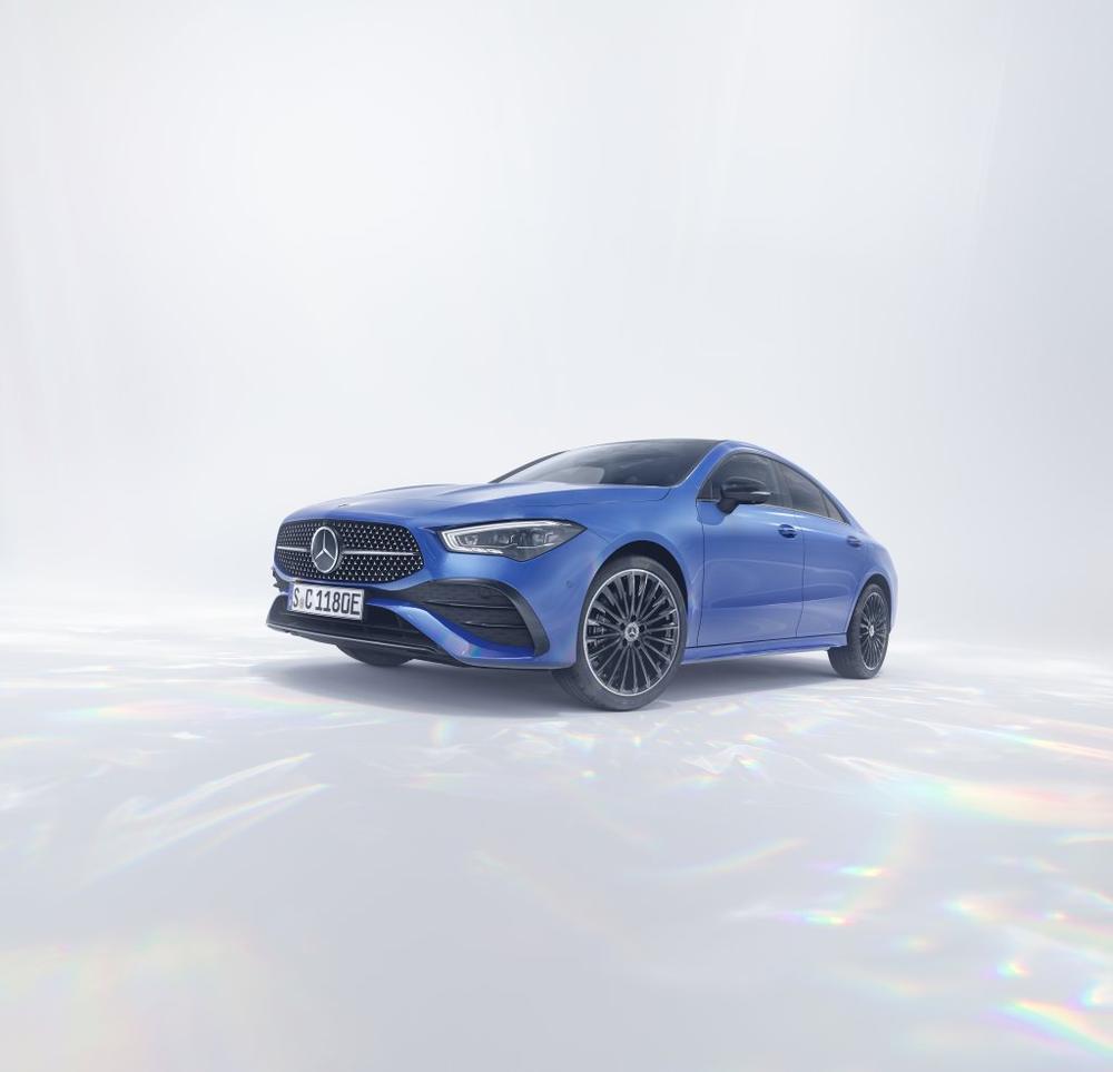 A blue Mercedes-Benz CLA Coupé in a bright studio with prisms of light on the floor