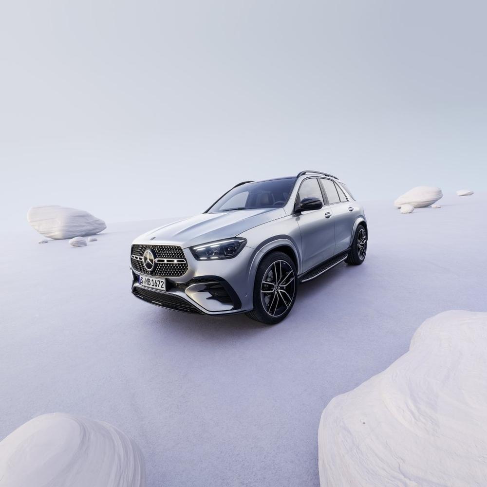 A silver Mercedes-Benz GLE in a staged, misty lilac scene of pale rock shapes